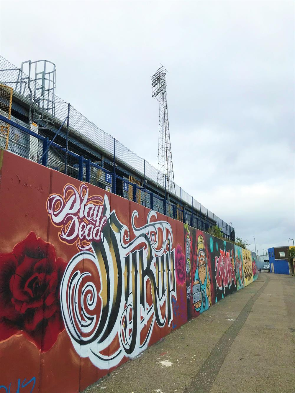 Street art overlooked by a floodlight at Fratton Park in Specks Lane, Portsmouth