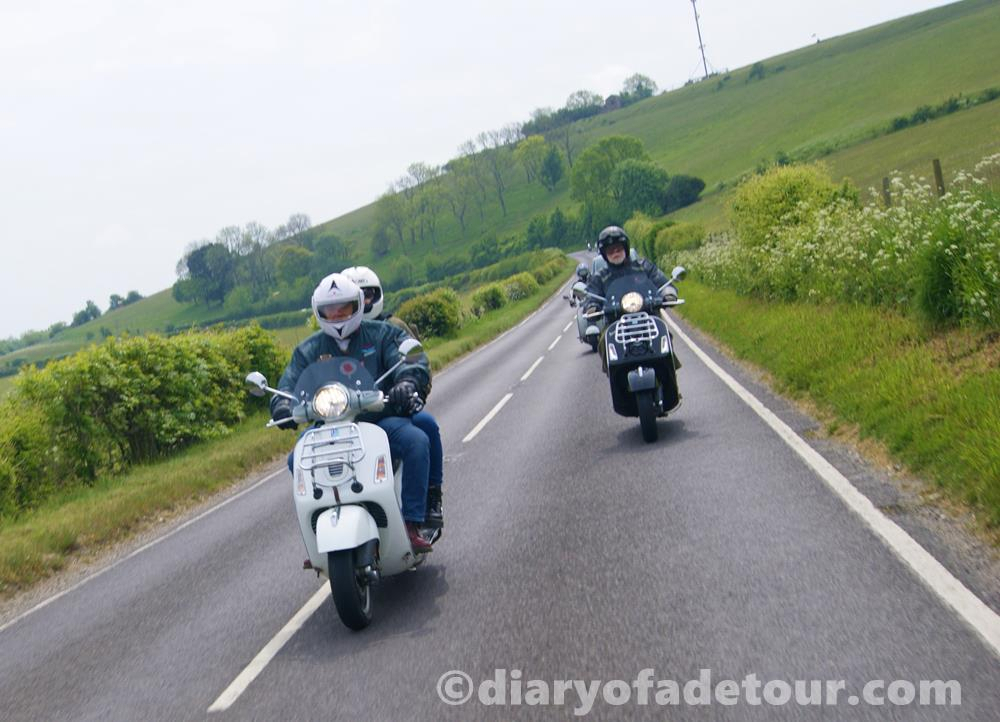 Vespa GTS scooters being ridden through West Sussex