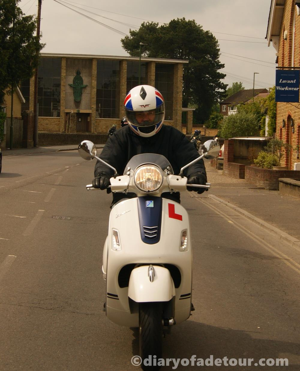White Vespa GTS scooter riding through Midhurst in West Sussex