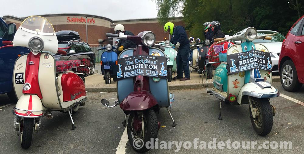 Three Lambretta scooters with legshield banners which read Dolphins Lambretta Club, Brighton