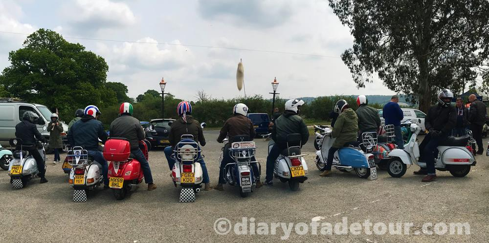 Rear view of scooters in a row about to leave a car park