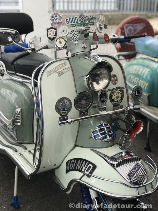 Green and grey Series 1 Lambretta with badges attached to the horn cover