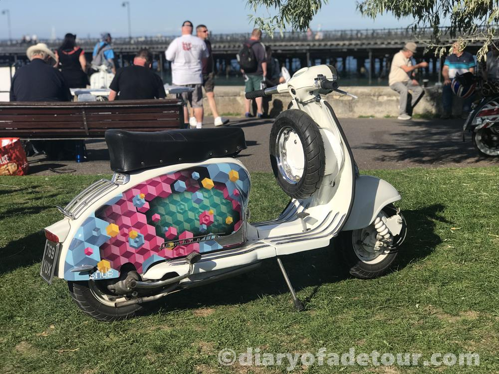 A series 2 Lambretta with street art on the side panels, on the green at Ryde at the Isle of Wight scooter rally