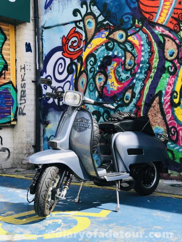Grey Lambretta GP in front of Brighton street art
