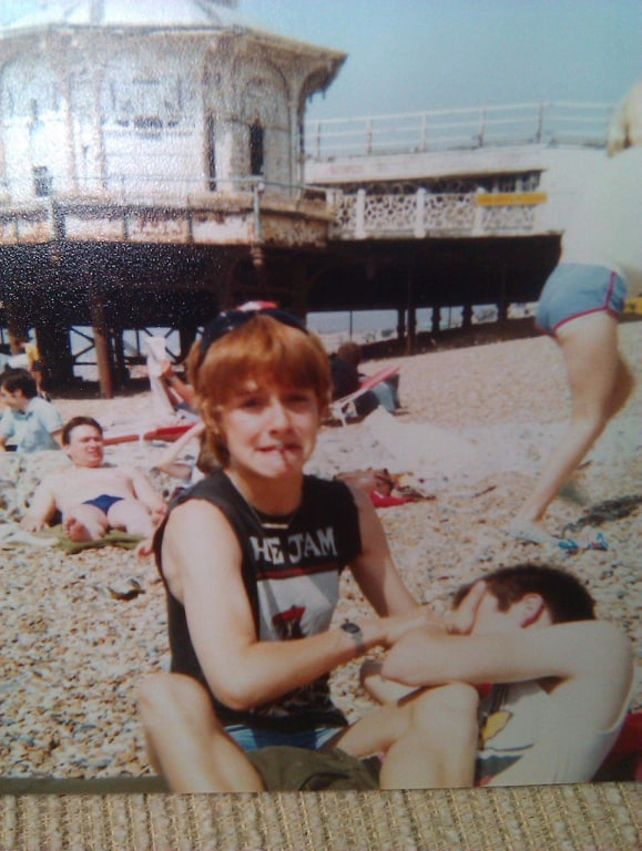 A 13 year old Sarah George wearing a The Jam t-shirt, sitting on Brighton beach at the Mod Rally in 1984.