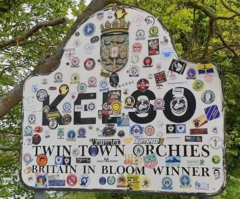 Kelso scooter rally, a town sign covered in scooter club stickers