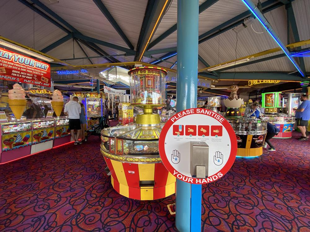 Hand sanitiser sign in the amusements on Weymouth seafront