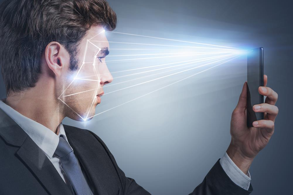 Man holding his mobile phone to do biometric face recognition