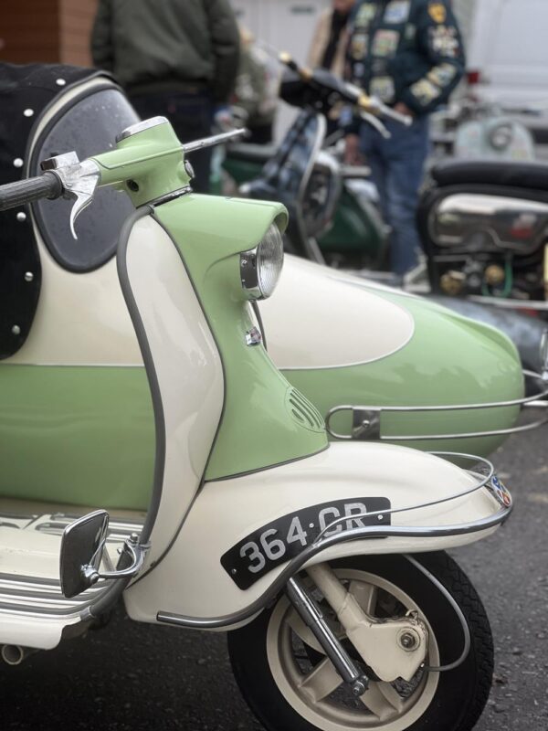 A restored Series 1 Lambretta in green and white with a Watsonian sidecar.