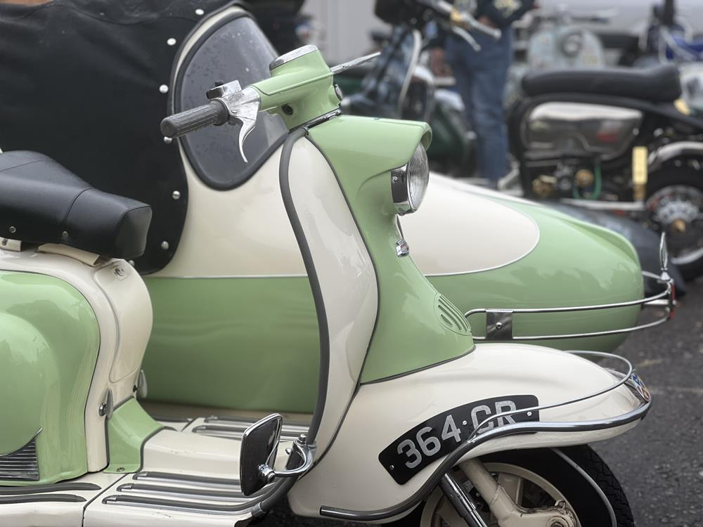 A restored Series 1 Lambretta in green and white with a Watsonian sidecar.