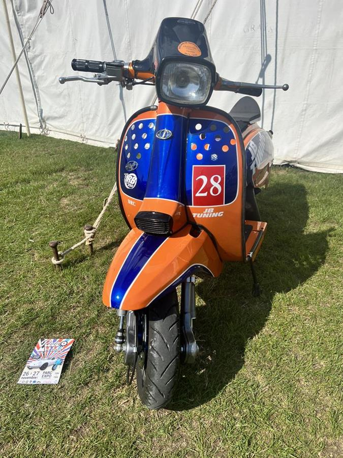 Tik Tester's Lambretta street racer - an orange and navy blue scooter with number 28 on the front.