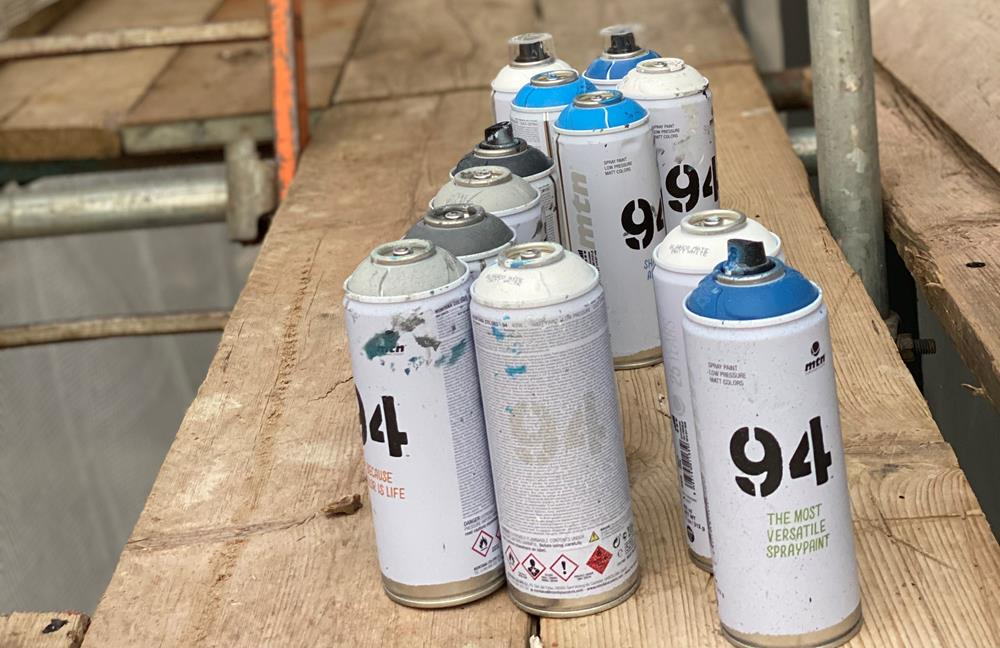 Graffiti paint cans arranged on some scaffolding boards