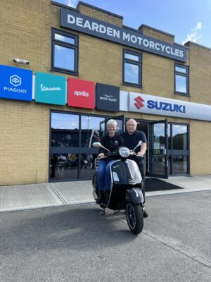 Ali Richards and Nigel from Dearden Motorcycles standing outside with a black GTS 300 HPE.