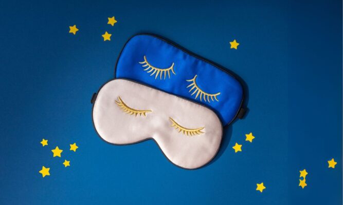 Two blue and white sleep masks on a blue background with yellow stars.